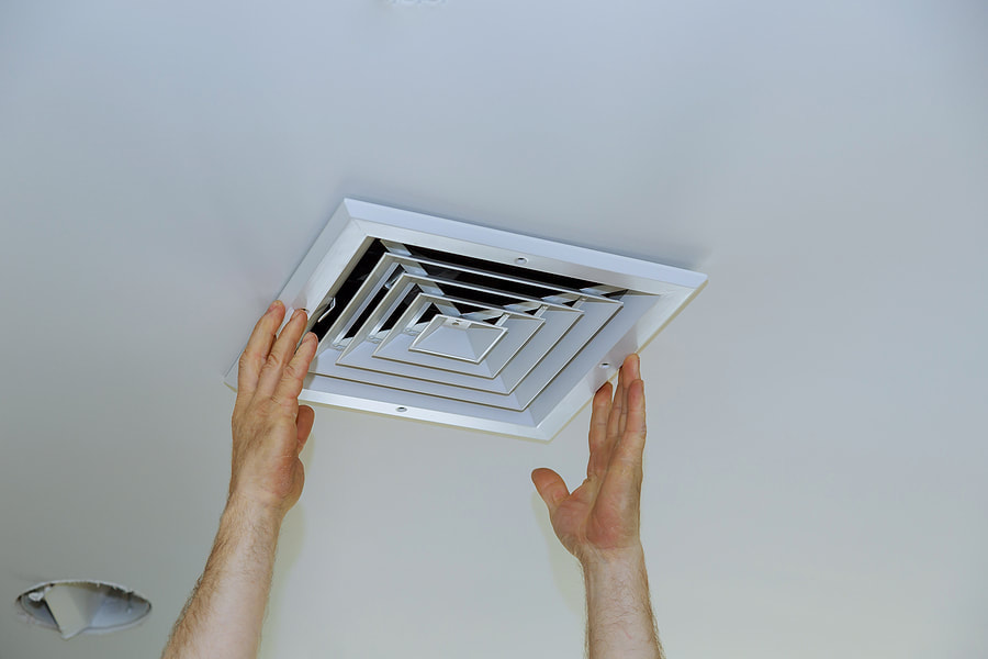 man pulling off an air vent